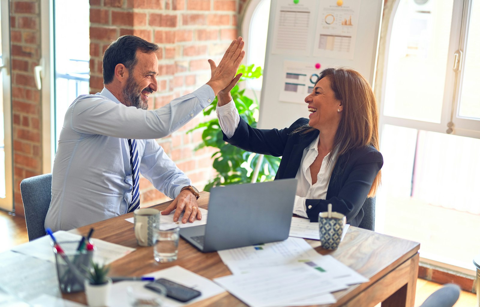 Two advisors celebrating an approved client application