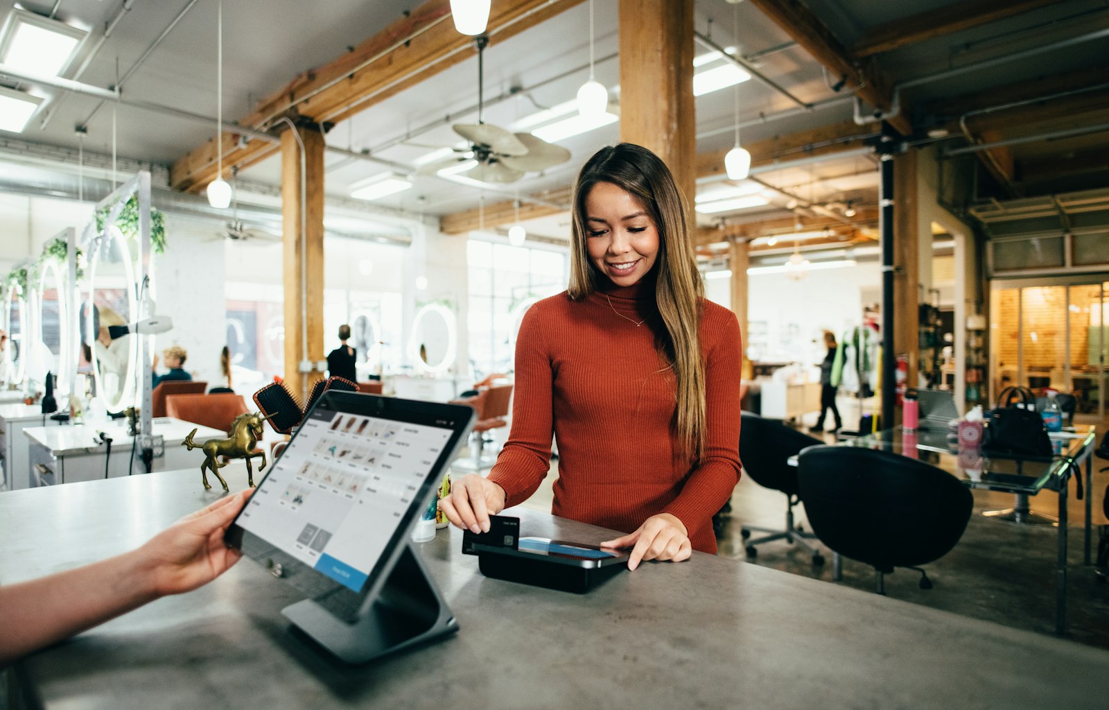 Small business owner taking a payment at her counter